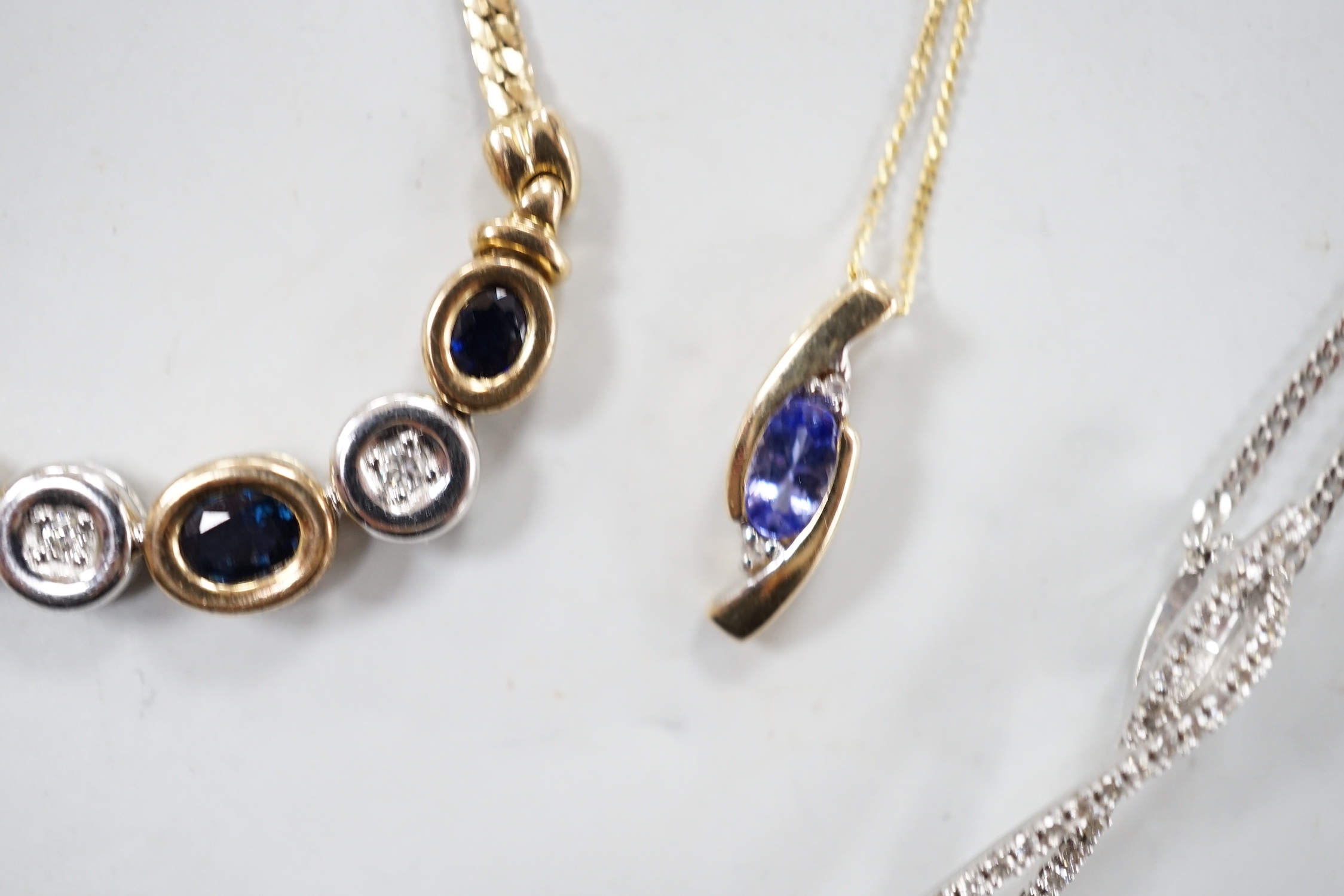 Four assorted modern 375 and gem set pendant necklaces, including white 375 and diamond chip set, 50cm and white 375 and emerald drop set, gross weight 11.3 grams.